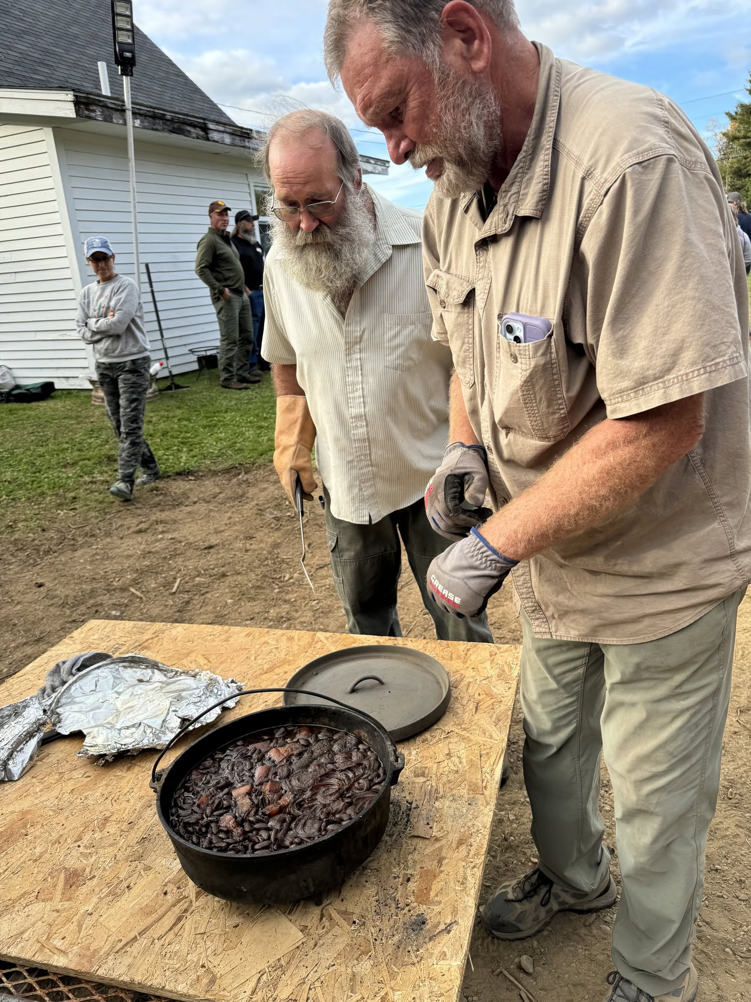 Board Members Gary Currier (right) and Steve Sherman pulling out the beanhole beans for a harvest supper.